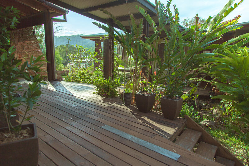 Stained timber deck with posts and potted plants in a home garden